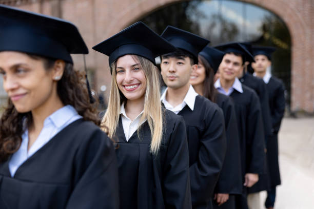 istock Student smiling in her graduation ceremony while standing in a row 2162665206