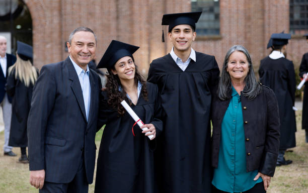 Happy Latin American family celebrating on graduation day and looking at the camera smiling - education concepts