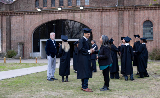 istock Students talking to their families outdoors after their graduation ceremony 2162665234