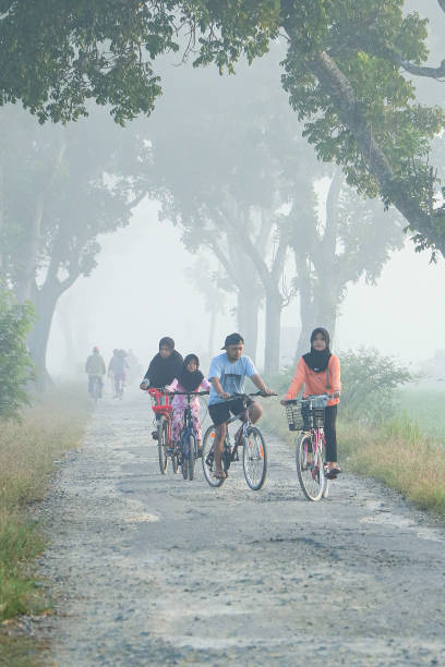 Cilacap, Indonesia - June 18, 2024 : four brothers doing cycling together on a cool and sunny morning