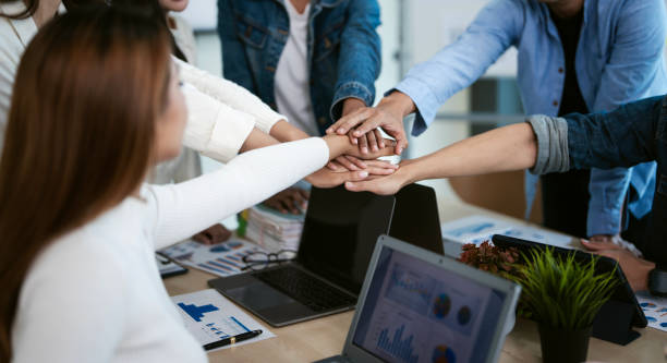 istock Group of young business people putting their hands together. Stack of hands. Unity and teamwork concept. 2162673644