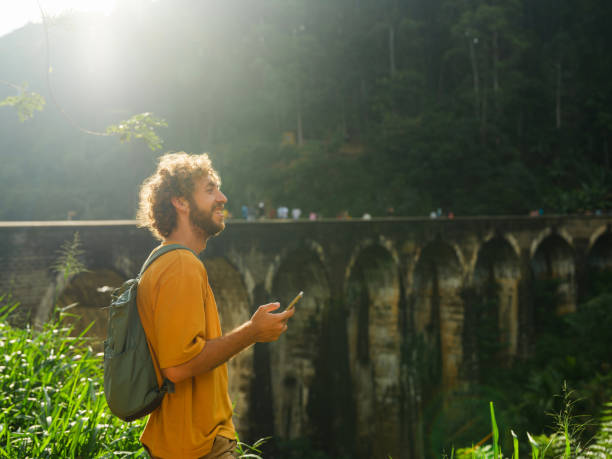 istock Man using smartphone near Nine Arch Bridge in Ella during trip to Sri Lanka 2162673698