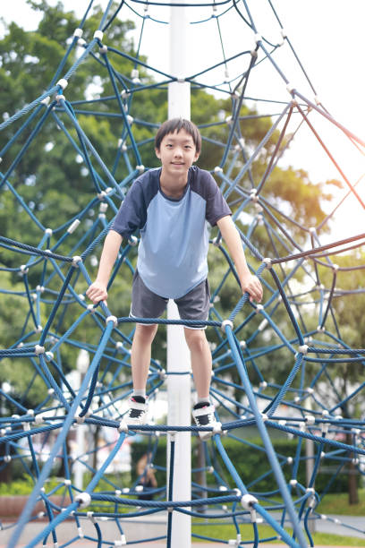 istock Young boy on climbing rope in playground 2162673707