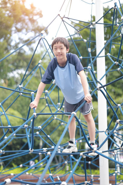 istock Young boy on climbing rope in playground 2162673709