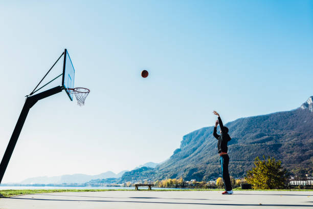 istock Basketball player throwing ball toward hoop 2162674748