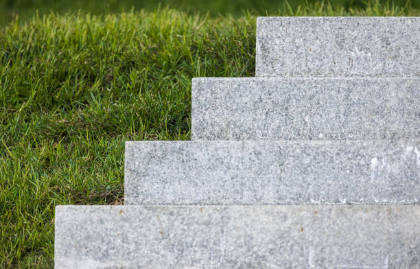 Stone stairway goes over green grass in a park, abstract architecture background photo