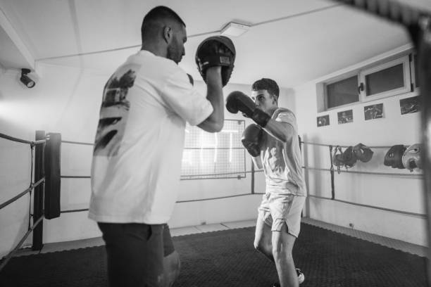 istock Young man at boxing training, he is sparring and practicing with his coach in boxing ring 2162685591
