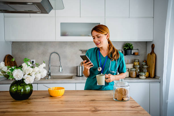 istock Young medical nurse using phone at home 2162688439