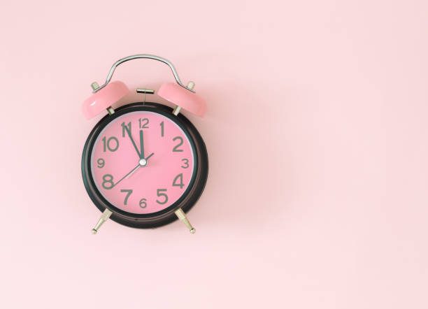 istock Pastel pink and black alarm clock on light pastel pink background with copy space. Minimal time concept. Flat lay. 2162689866