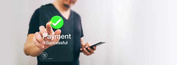 istock A person completes a successful mobile payment, with a green checkmark and Payment Successful text displayed on a transparent virtual screen. 2162690278