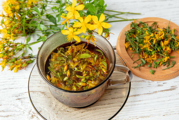 istock Hypericum perforatum commonly known as St John's wort, perforate St John's wort or common St John's wort herbal tea in glass on white wood board background. 2162690416