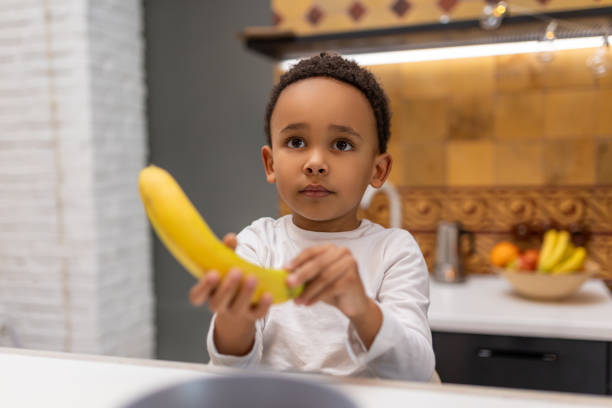 istock Cute little boy with banana in his hands 2162697808