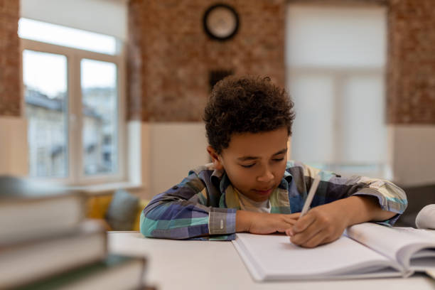 istock African american boy doing lessons and writing something in a notebook 2162697839