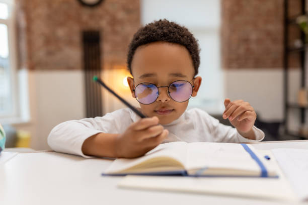 istock African american boy doing lessons and writing something in a notebook 2162697840