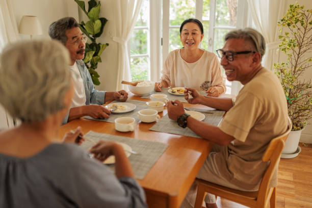 istock Elderly friends enjoying a meal together 2162704996