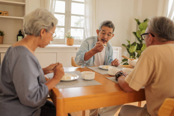 istock Elderly friends enjoying a meal together 2162705190