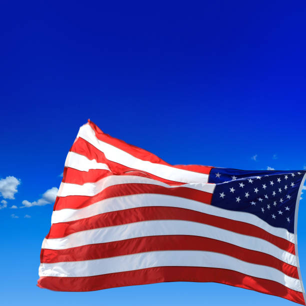 istock Waving American flag over sunny blue sky 2162707804