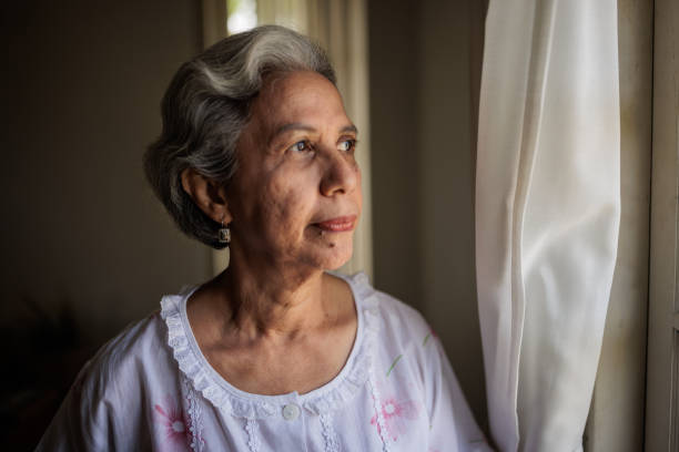 istock Elderly woman looking out the window 2162707806
