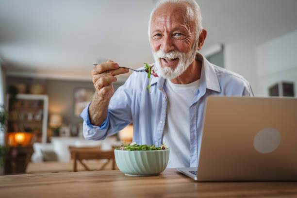 istock Senior caucasian man use laptop while eat salad at home 2162708554