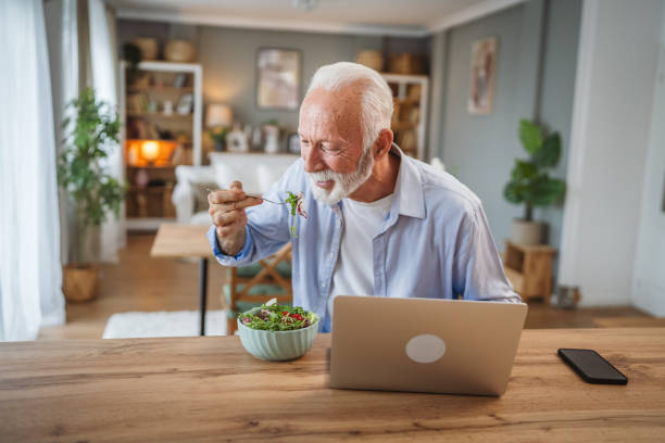 istock Senior caucasian man use laptop while eat salad at home 2162709548
