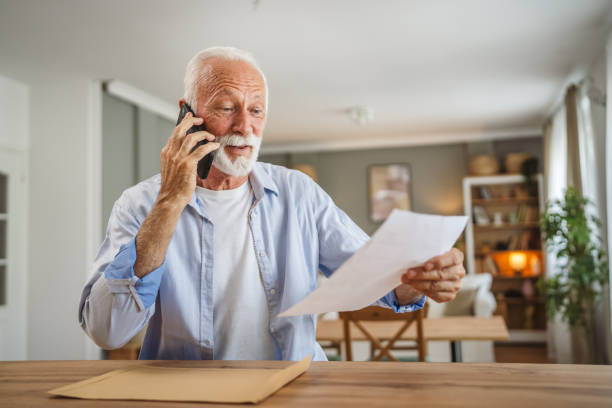 istock Senior man sit at home have a phone call while receive good report 2162709601