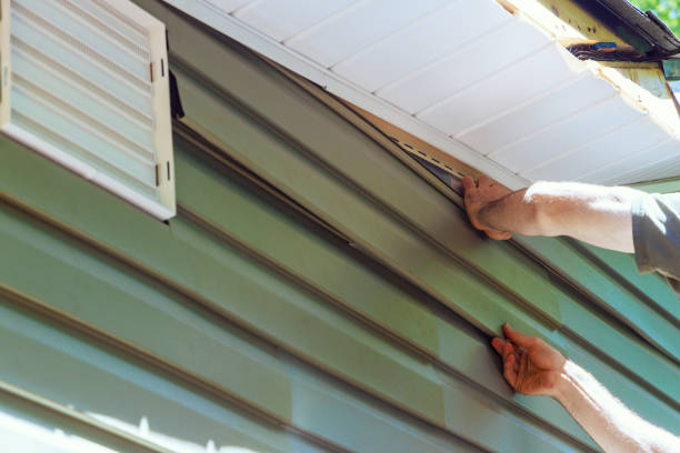 istock Construction employee installs vinyl plastic siding panels on a new house wall facade 2162711987