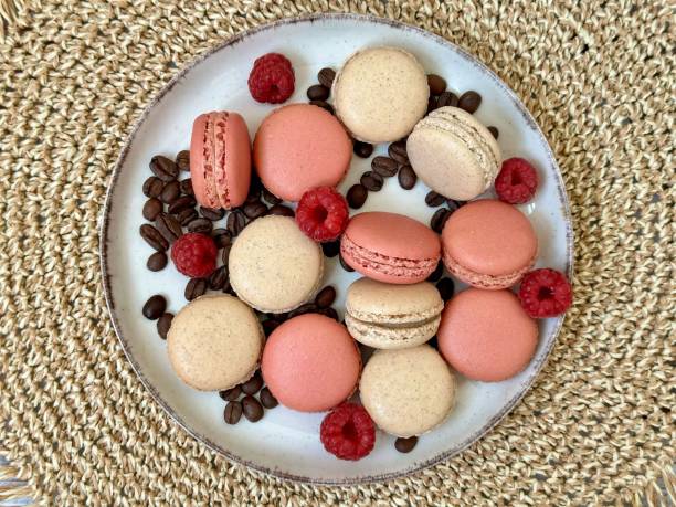 istock Macarons, raspberries and coffee beans on the beige plate 2162713885