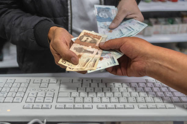 istock Man's hands with Colombian coins and bills 2162716095