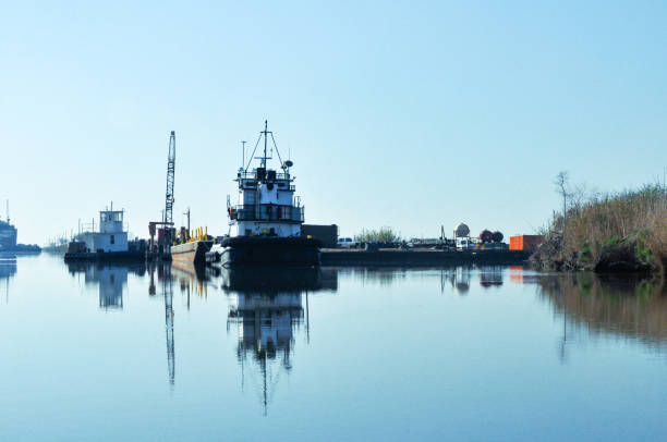 Savannah, Georgia, USA - 20 February 2024: A tugboat maneuvers alongside a large cargo vessel, ensuring safe navigation through the bustling port waters.