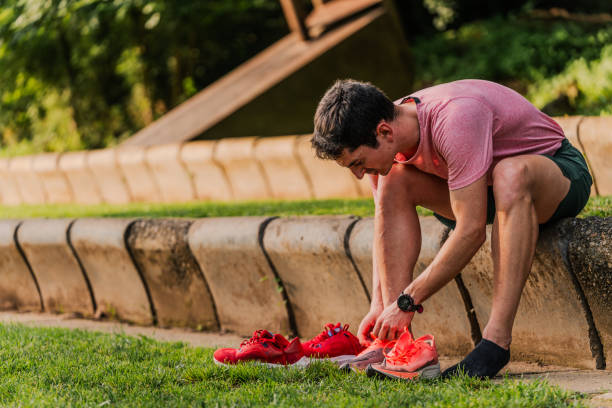 istock Seated athlete changing his running shoes during track training 2162719984