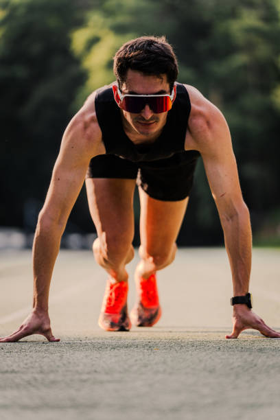 istock Expert athlete in starting position staring straight ahead with focused face. Vertical 2162720041
