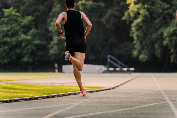 istock Athlete seen from behind running on the outdoors track. Copy space 2162720063