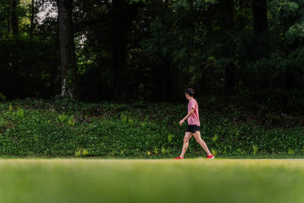 Athletic trainer walking calmly around the track with copy space