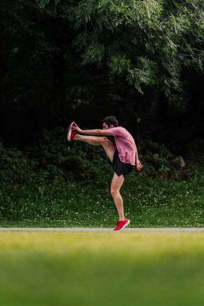 istock Young man lifting his legs to warm up before going for a run. Vertical 2162720153