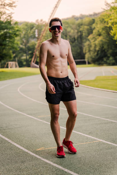 istock Happy shirtless athlete during training session at the athletics track 2162720164