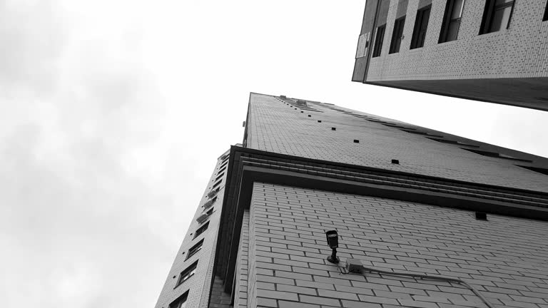Black and white brick real estate, urban style building with windows,apartments. Urban architecture view from below.
