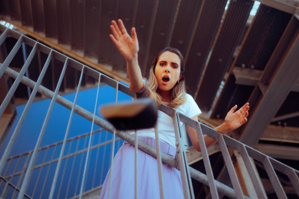 A girl in a white T-shirt and blue shorts is standing on a staircase entering the school. She is wearing a backpack and white socks. The image has a casual, relaxed feel to it.