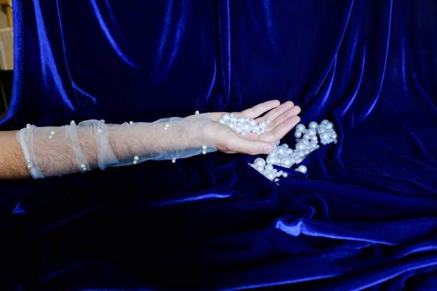 Masculine Hands Wearing Sheer Gloves Against Pearls and glass backdrop