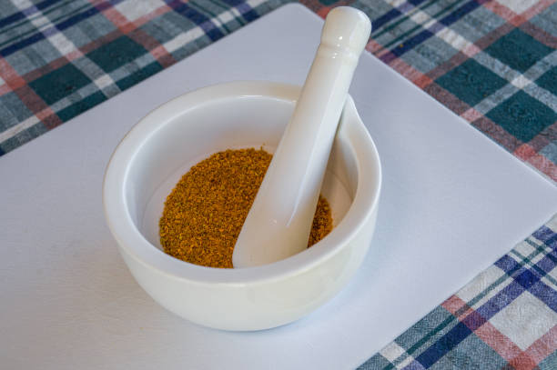 Turmeric powder with mortar and pestle, on a white board with table cloth