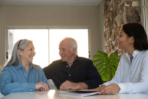 istock Mature couple going over paperwork with young social worker at community 2162731873