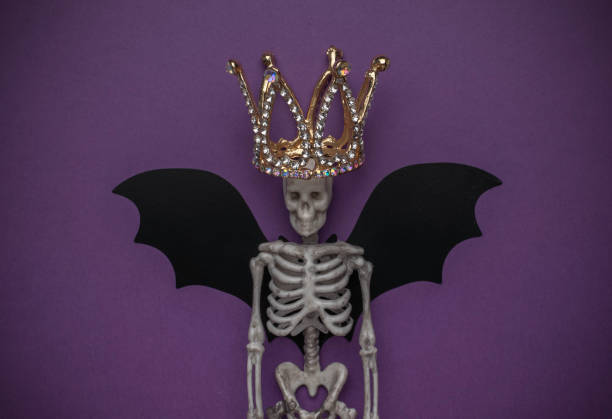 istock Skeleton with Crown and Bat Wings on Purple Background 2162736933
