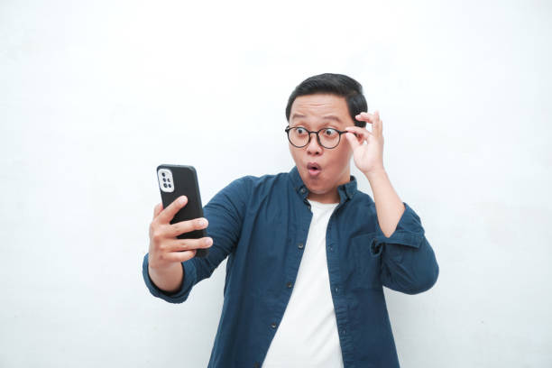 istock young man look to smartphone with shocked expression 2162737953