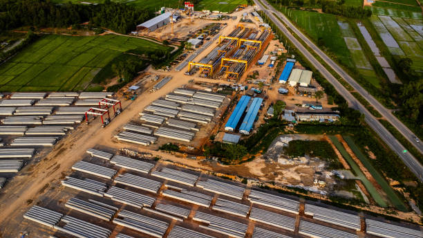 istock Aerial view of a new road development or highway under construction. Top view from a drone over road construction workers amidst mountains. Construction Site with Cranes and Heavy Equipment. 2162738837