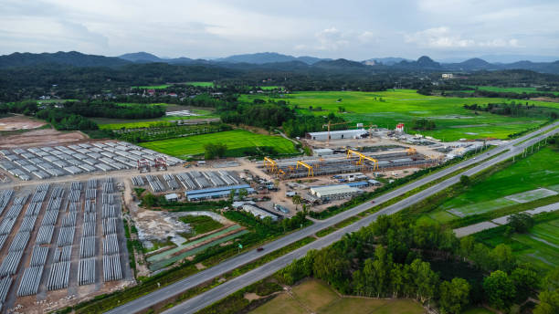 istock Aerial view of a new road development or highway under construction. Top view from a drone over road construction workers amidst mountains. Construction Site with Cranes and Heavy Equipment. 2162738880