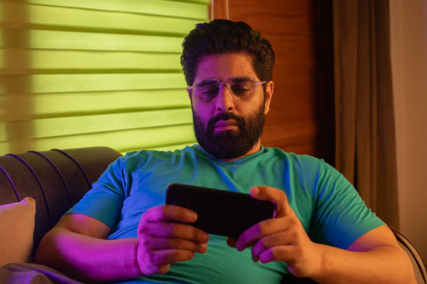 istock Man reading good news over mobile phone on sofa 2162744384