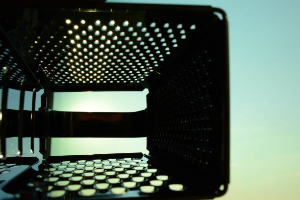 A macro shot capturing the abstract, textured pattern of a shiny metal grater or perforated surface. the repetitive holes and reflection create a metallic background.