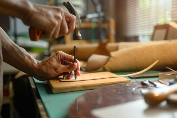 istock Professional craftsman using a hammer and other tools to shape and detail the leather piece 2162746509