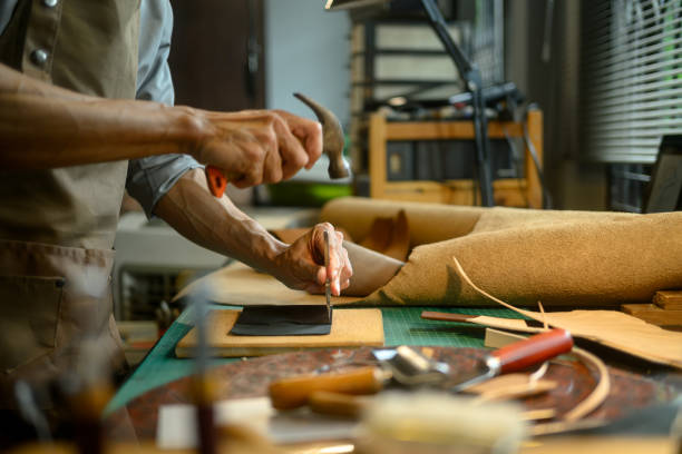 istock Professional craftsman using a hammer and other tools to shape and detail the leather piece 2162746510