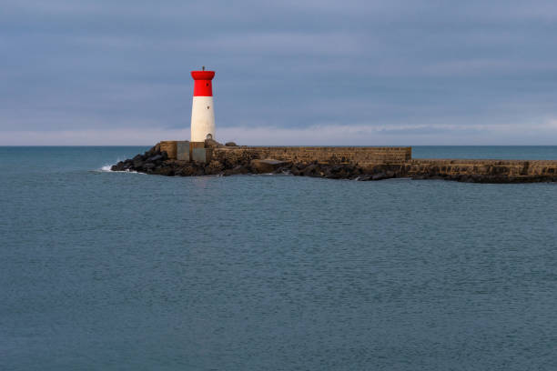 istock A lighthouse is on a rocky shoreline 2162747219