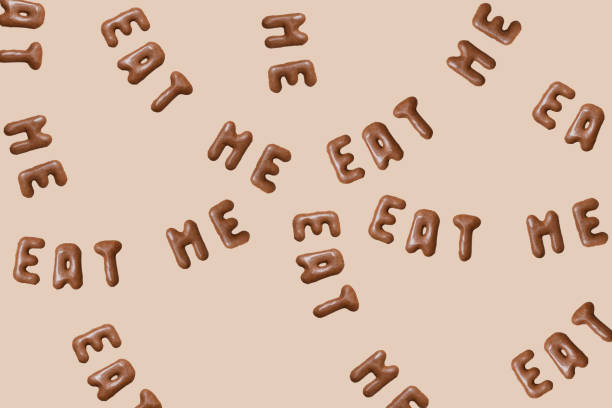 Sweet composition with the words Eat Me on a beige background. Alphabet biscuits on a pastel background, top view, copy space